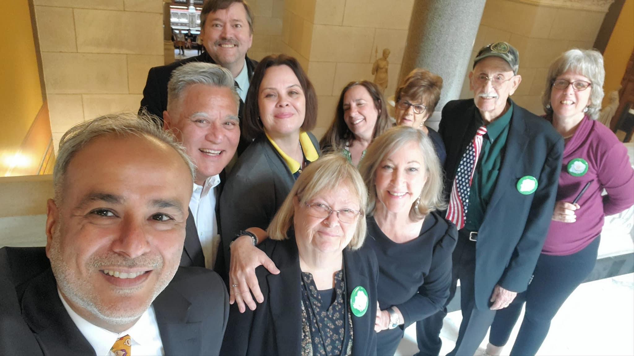 A photograph of several members of the Connecticut Witch Trial Exoneration Project and CT WITCH Memorial posing with legislators after the adoption of the resolution absolving Connecticut's witch trial victims